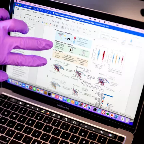computer with purple glove hand